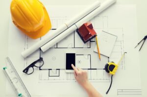 close up of hand with blueprint and smartphone
